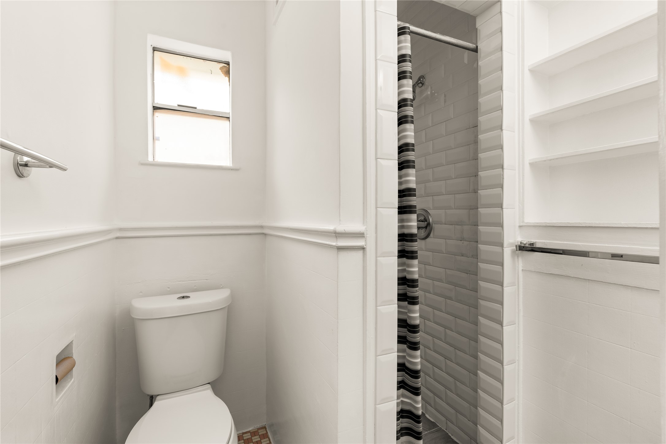 2202 West Main Street Houston, TX 77098 - Photo 26 of 32 a white toilet sitting next to a shower