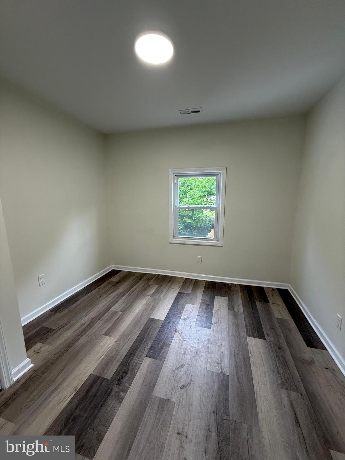 516 Columbus Road Burlington, NJ 08016 - Photo 8 of 12 an empty room with wooden floor and windows