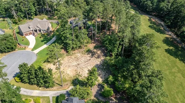 an aerial view of residential house with outdoor space and trees all around
