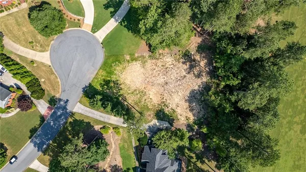 an aerial view of residential house with outdoor space and trees all around