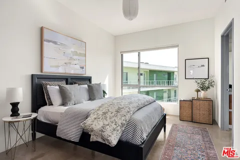 a bedroom with a large bed couch and a window