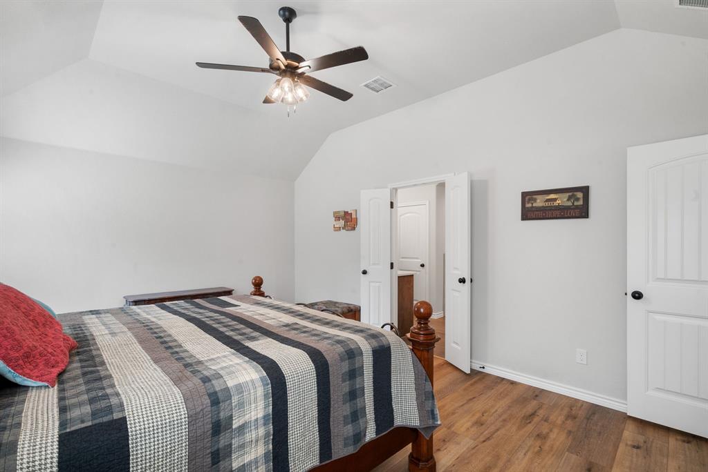 355 Sunset Cove Bluff Dale, TX 76433 - Photo 26 of 40 a bedroom with a bed and a chandelier