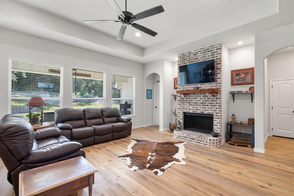 355 Sunset Cove Bluff Dale, TX 76433 - Photo 9 of 40 a living room with furniture a flat screen tv and a fireplace