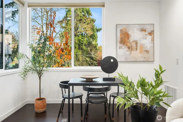 a vase of flowers sitting on a table with a potted plant