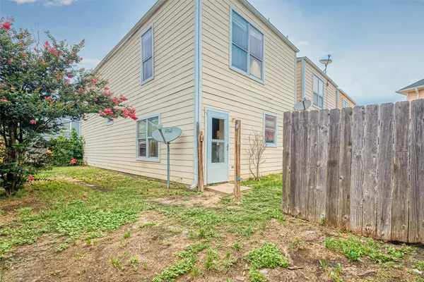 a view of a house with backyard and wooden fence