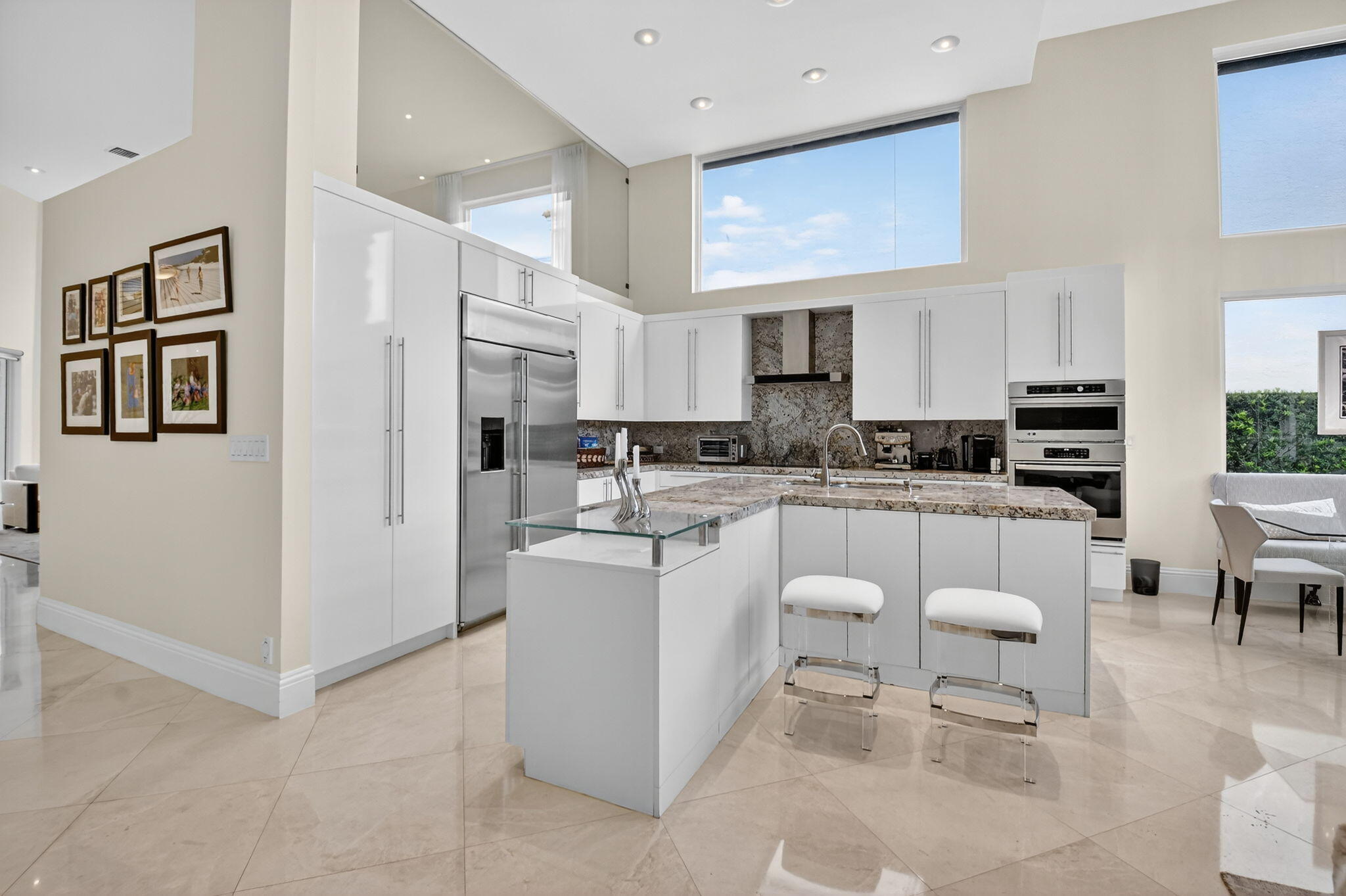 2563 Northwest 63rd Street Boca Raton, FL 33496 - Photo 12 of 65 a kitchen with white cabinets and stainless steel appliances