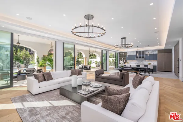 a living room with furniture floor to ceiling window and wooden floor