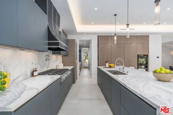 a kitchen with stainless steel appliances granite countertop a sink a stove and a wooden floors