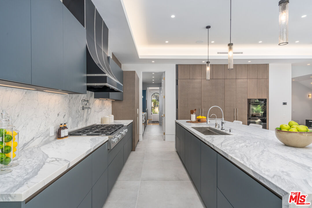 611 North Hillcrest Road Beverly Hills, CA 90210 - Photo 17 of 65 a kitchen with stainless steel appliances granite countertop a sink a stove and a wooden floors