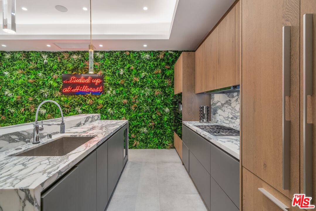 611 North Hillcrest Road Beverly Hills, CA 90210 - Photo 35 of 65 a kitchen with kitchen island granite countertop lots of counter top space and sink
