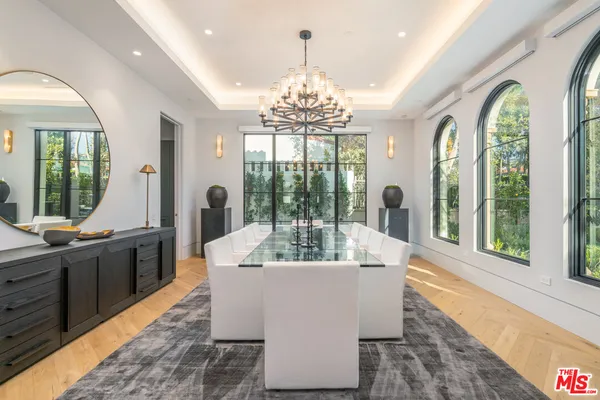 a view of a dining room with furniture a chandelier and wooden floor
