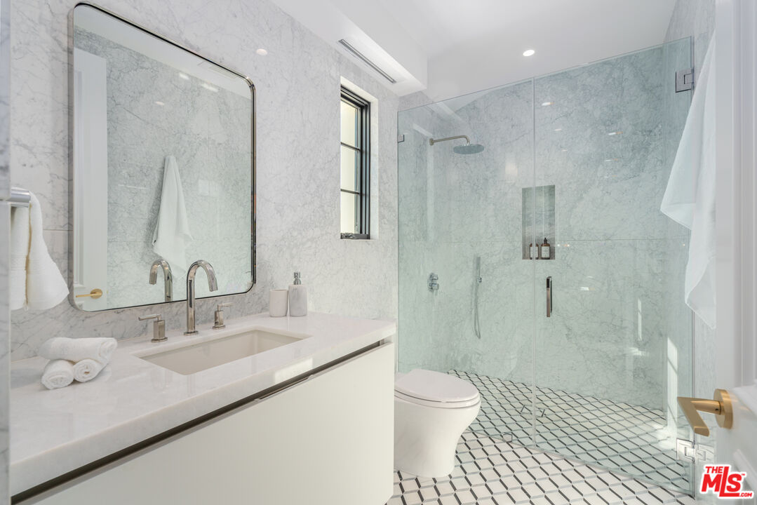 611 North Hillcrest Road Beverly Hills, CA 90210 - Photo 50 of 65 a bathroom with a sink a toilet and shower
