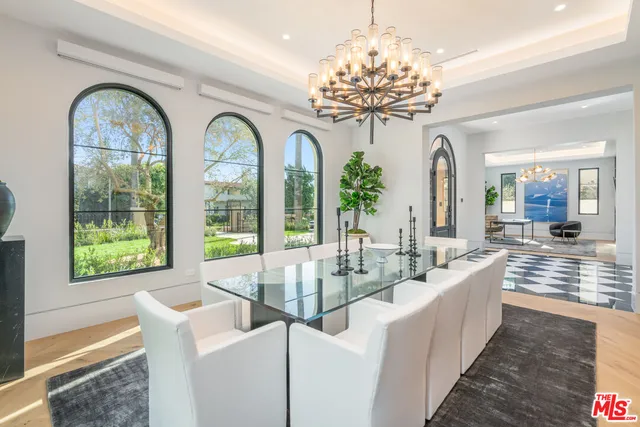 a view of a dining room with furniture a chandelier and wooden floor