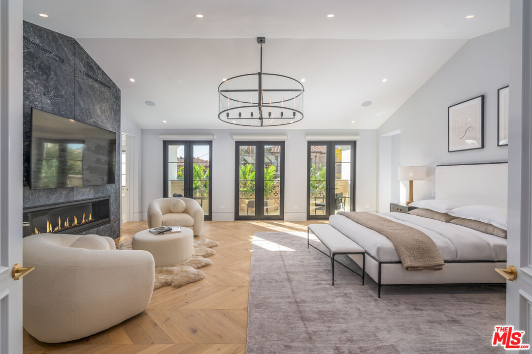 611 North Hillcrest Road Beverly Hills, CA 90210 - Photo 51 of 65 a spacious bedroom with a bed and a chandelier