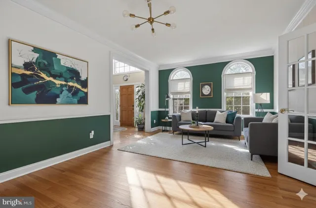 a view of a kitchen with kitchen island stainless steel appliances wooden floor and living room view