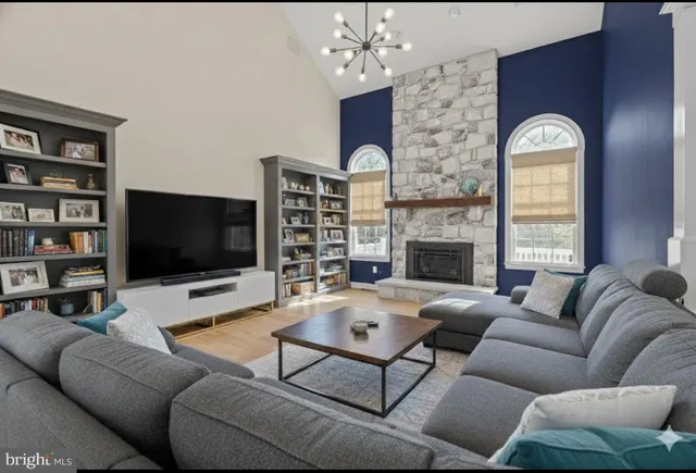 a living room with furniture a bookshelf and a window
