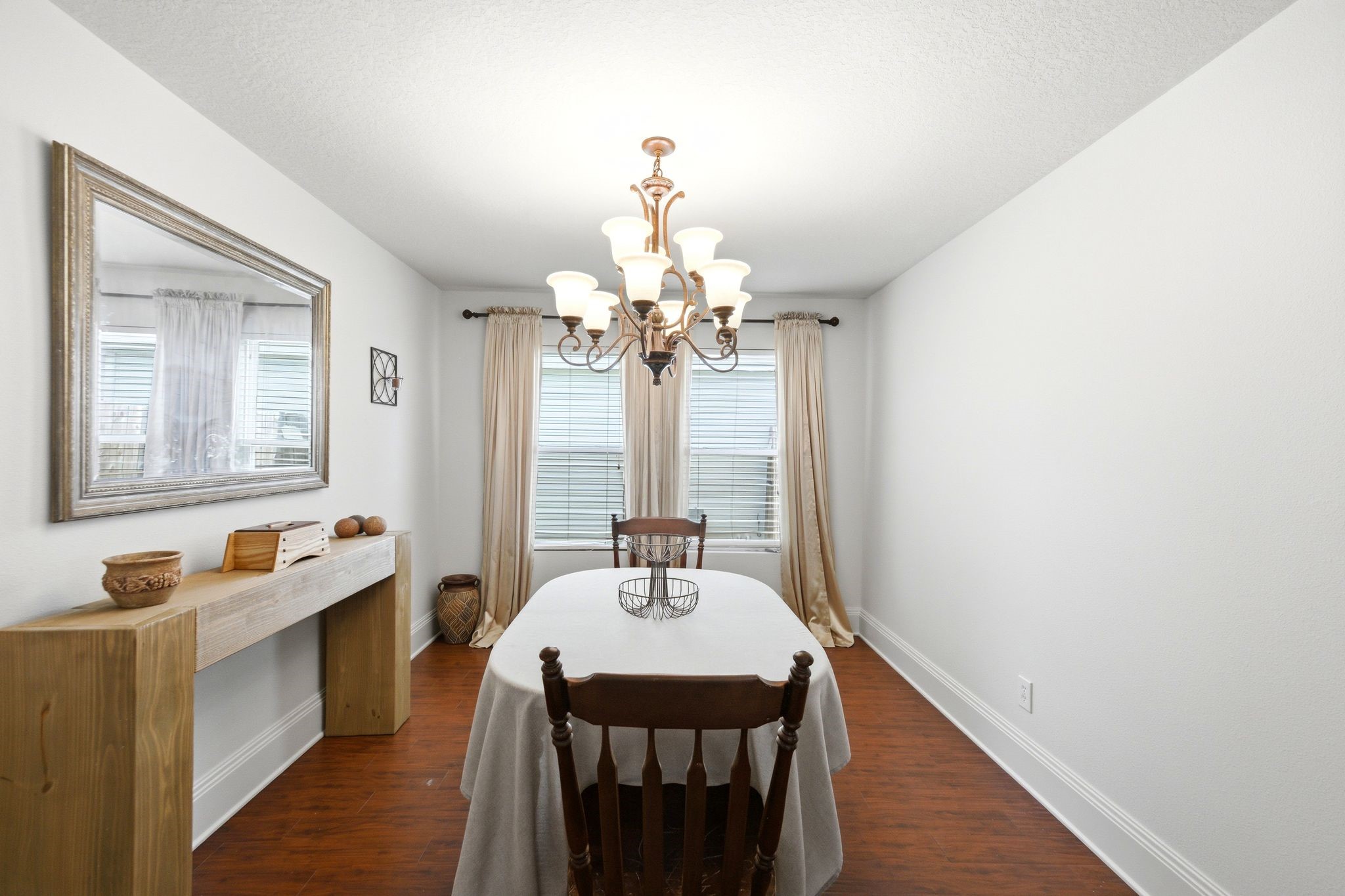 16954 Tableland Trail Conroe, TX 77385 - Photo 13 of 33 Formal dining room with hardwood floors, crown molding, elegant chandelier, and abundant natural light. Perfect for family meals, holiday celebrations, and entertaining guests.