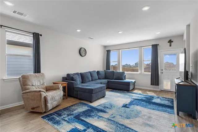 a living room with furniture wooden floor and a flat screen tv