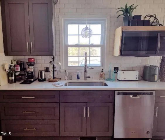a kitchen with stainless steel appliances granite countertop a sink a stove and cabinets