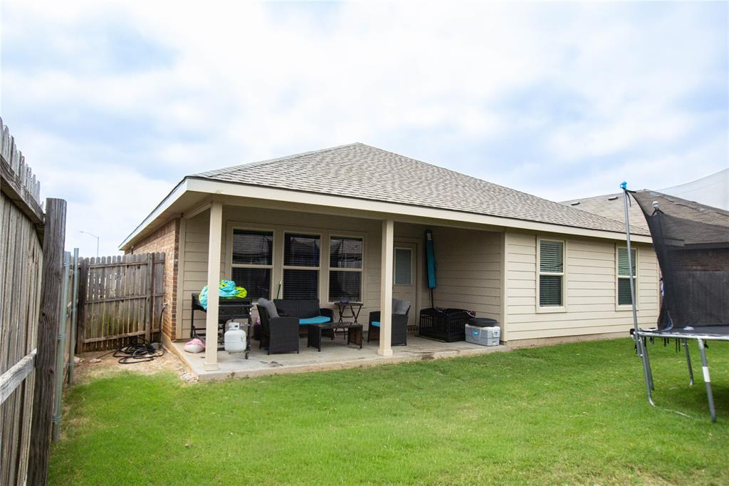 3204 Quiet Valley Road Fort Worth, TX 76123 - Photo 4 of 5 Expansive grassy backyard featuring a covered patio, tan siding, and a partial privacy fence