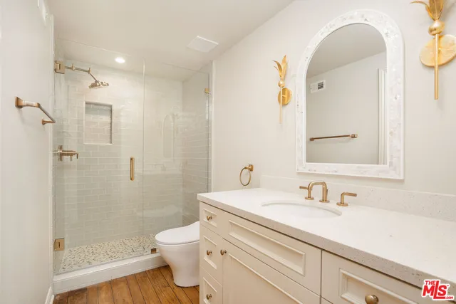 an empty room with wooden floor a ceiling fan and windows