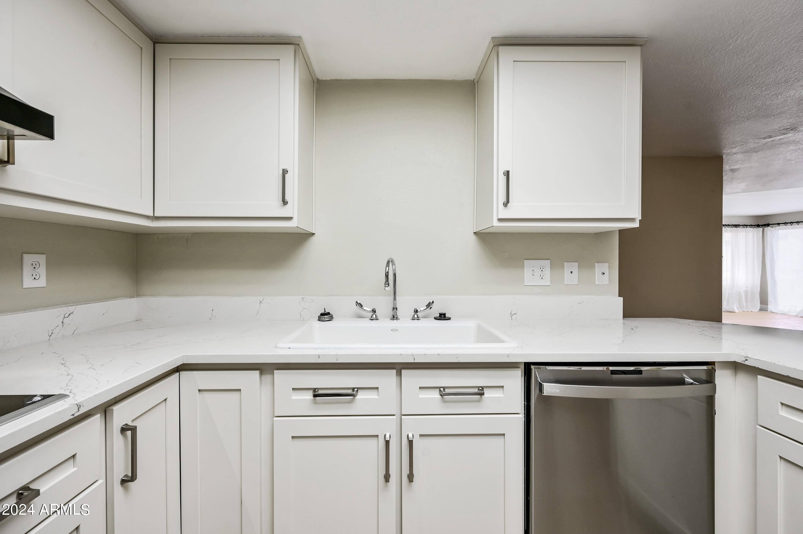 17404 North 99th Avenue, Unit 338 Sun City, AZ 85373 - Photo 15 of 27 a kitchen with white cabinets and a sink