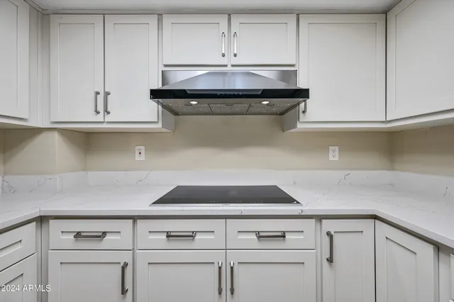 a kitchen with white cabinets and refrigerator