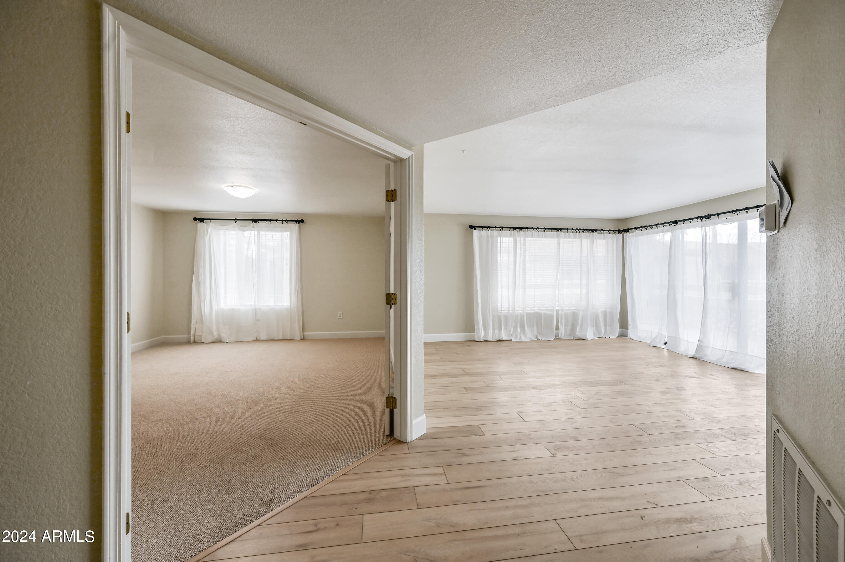 17404 North 99th Avenue, Unit 338 Sun City, AZ 85373 - Photo 18 of 27 a view of an empty room with window and wooden floor