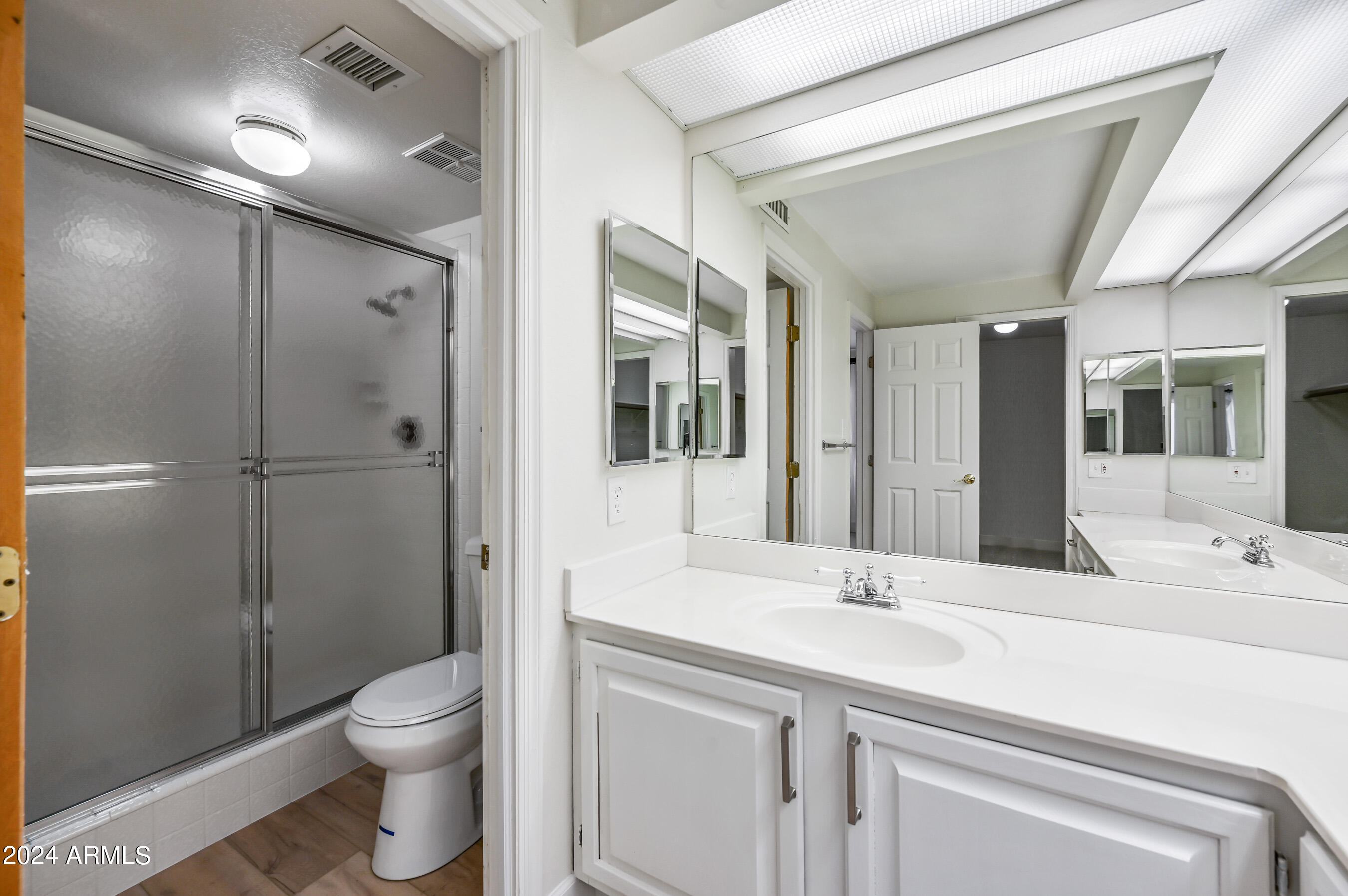 17404 North 99th Avenue, Unit 338 Sun City, AZ 85373 - Photo 22 of 27 a bathroom with a double vanity sink toilet and shower
