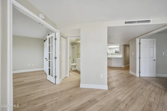 an empty room with wooden floor and windows
