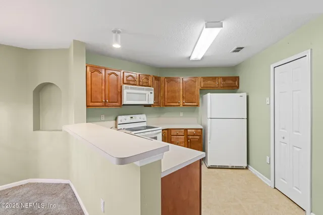 a kitchen with stainless steel appliances a refrigerator a sink a stove a microwave a counter top and cabinets