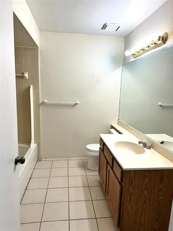 a bathroom with a sink a toilet a mirror and shower
