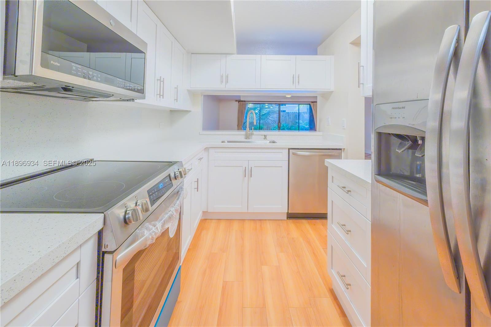 a kitchen with a sink a stove top oven and cabinets