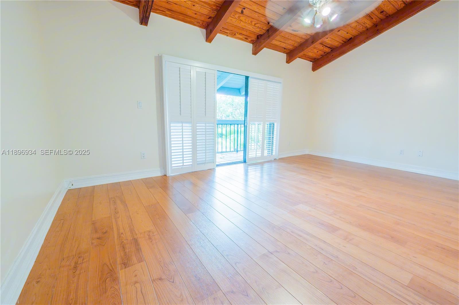 7890 Southwest 86th Street, Unit 11 Miami, FL 33156 - Photo 14 of 31 a view of an empty room with wooden floor and a window