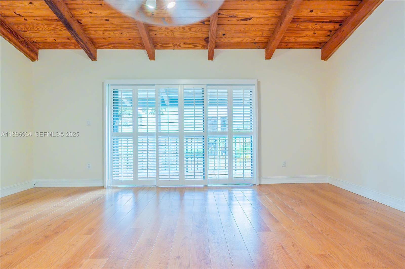 7890 Southwest 86th Street, Unit 11 Miami, FL 33156 - Photo 15 of 31 an empty room with wooden floor and windows