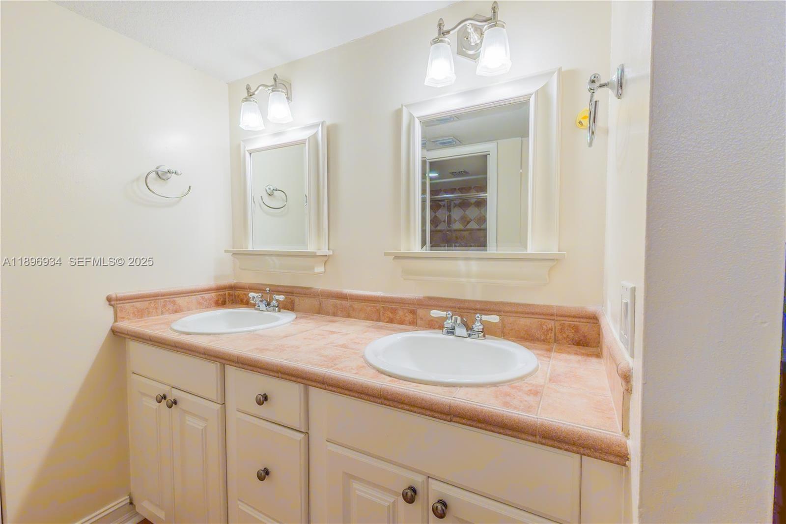 7890 Southwest 86th Street, Unit 11 Miami, FL 33156 - Photo 17 of 31 a bathroom with a sink and a mirror