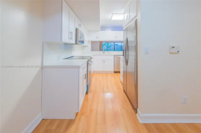 a kitchen with white cabinets and a sink