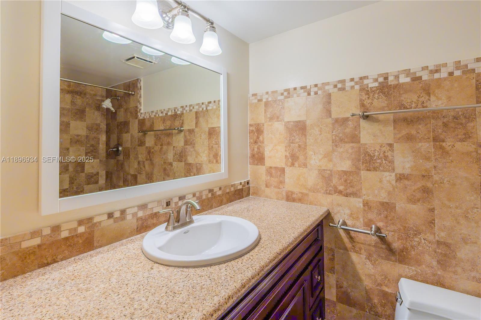 7890 Southwest 86th Street, Unit 11 Miami, FL 33156 - Photo 22 of 31 a bathroom with a sink and a mirror