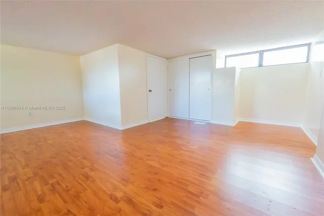 a view of empty room with wooden floor
