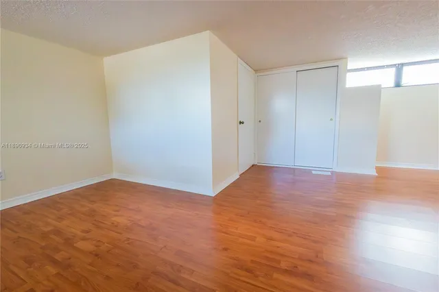 a view of an empty room with wooden floor