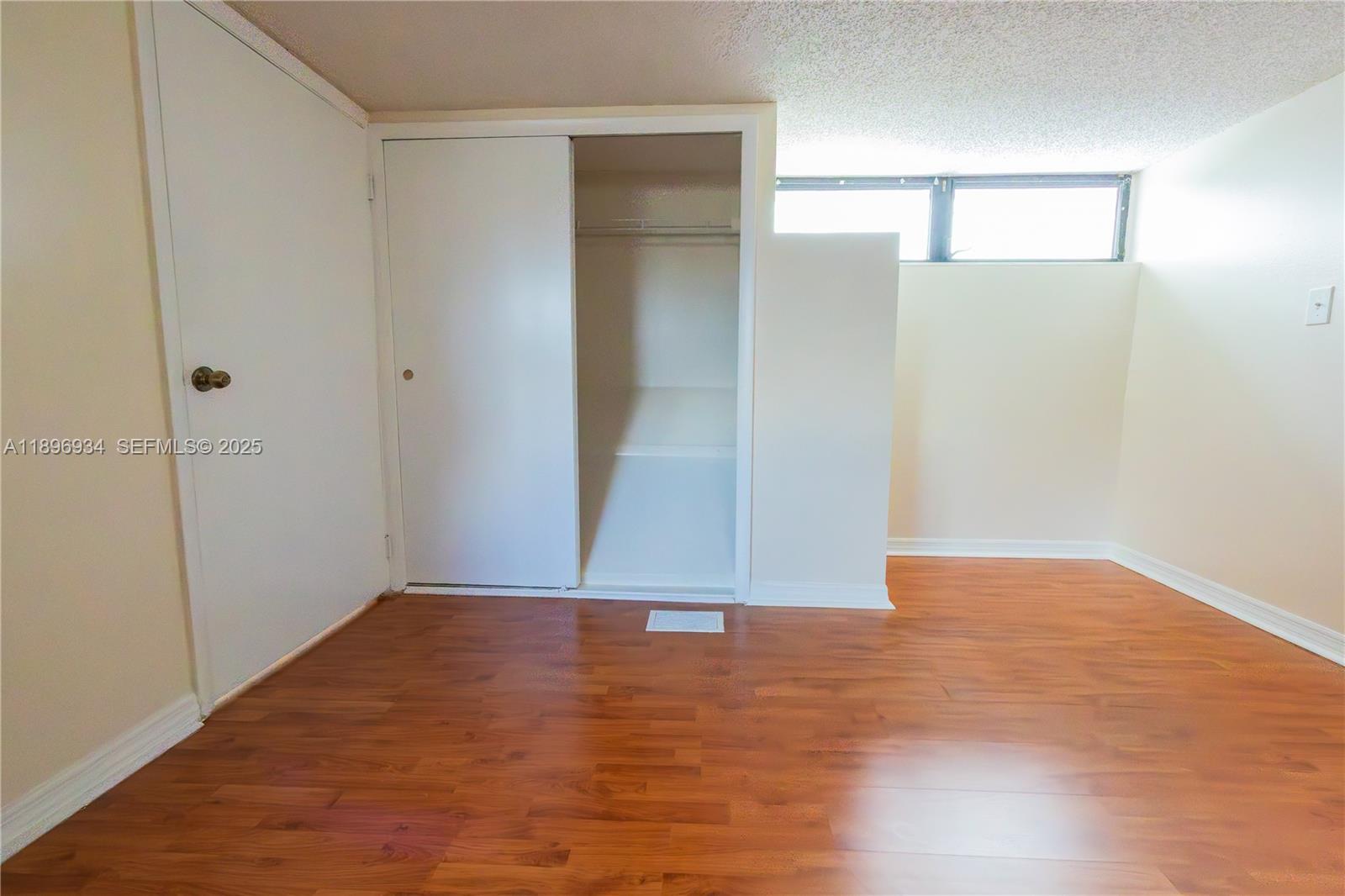 7890 Southwest 86th Street, Unit 11 Miami, FL 33156 - Photo 29 of 31 a view of an empty room with wooden floor
