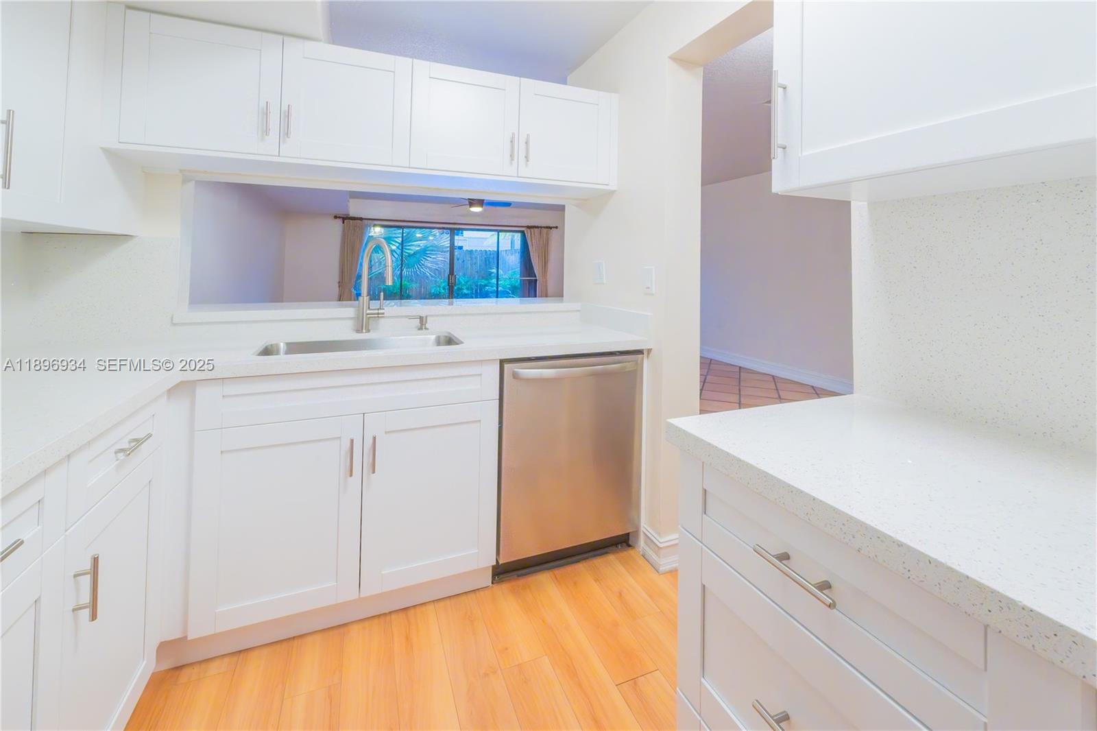 7890 Southwest 86th Street, Unit 11 Miami, FL 33156 - Photo 3 of 31 a kitchen with white cabinets and a sink