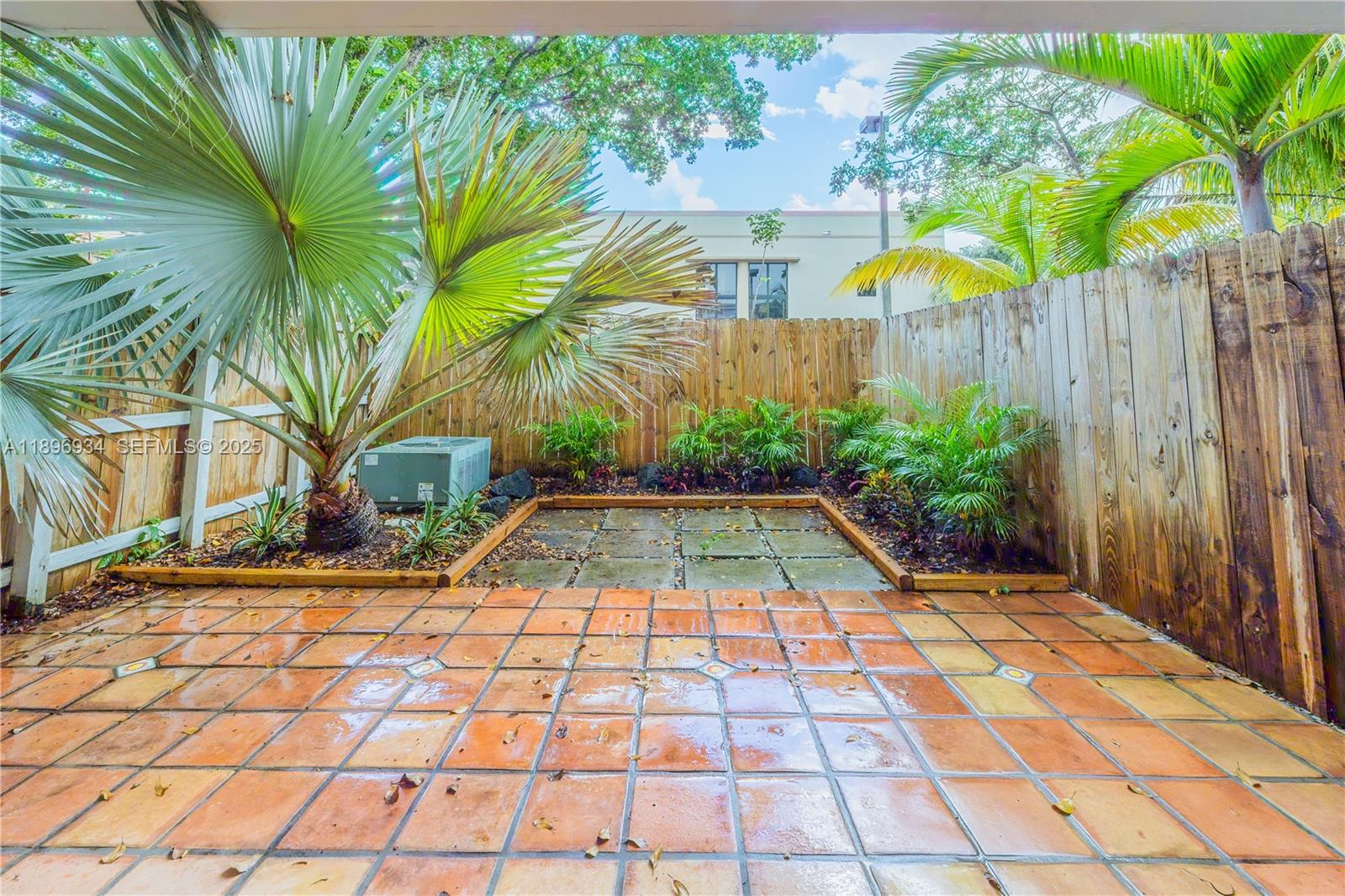 7890 Southwest 86th Street, Unit 11 Miami, FL 33156 - Photo 7 of 31 a backyard of a house with potted plants and palm trees