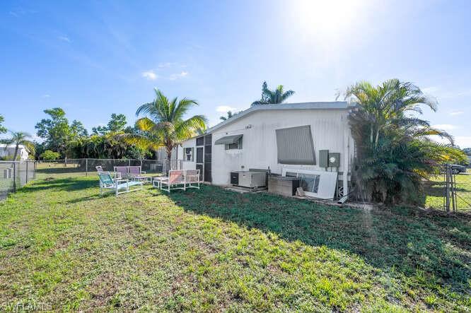 131 Grassy Key Lane, Unit 44 Naples, FL 34114 - Photo 28 of 30 Rear view of house featuring a yard