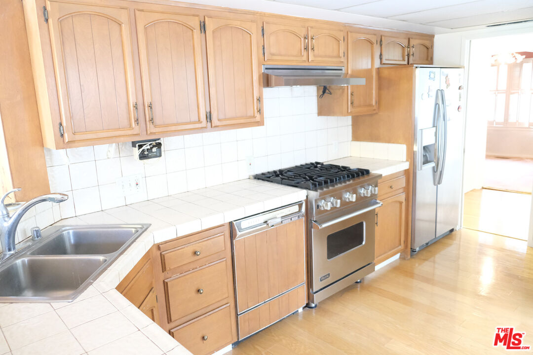 Undisclosed Address Los Angeles, CA 90066 - Photo 8 of 27 a kitchen with granite countertop a sink stove and refrigerator