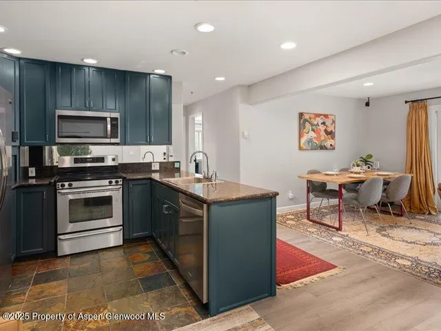 a kitchen with stainless steel appliances a stove a sink and a microwave