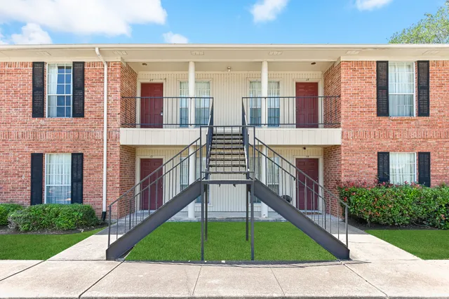 a view of a brick house with a yard