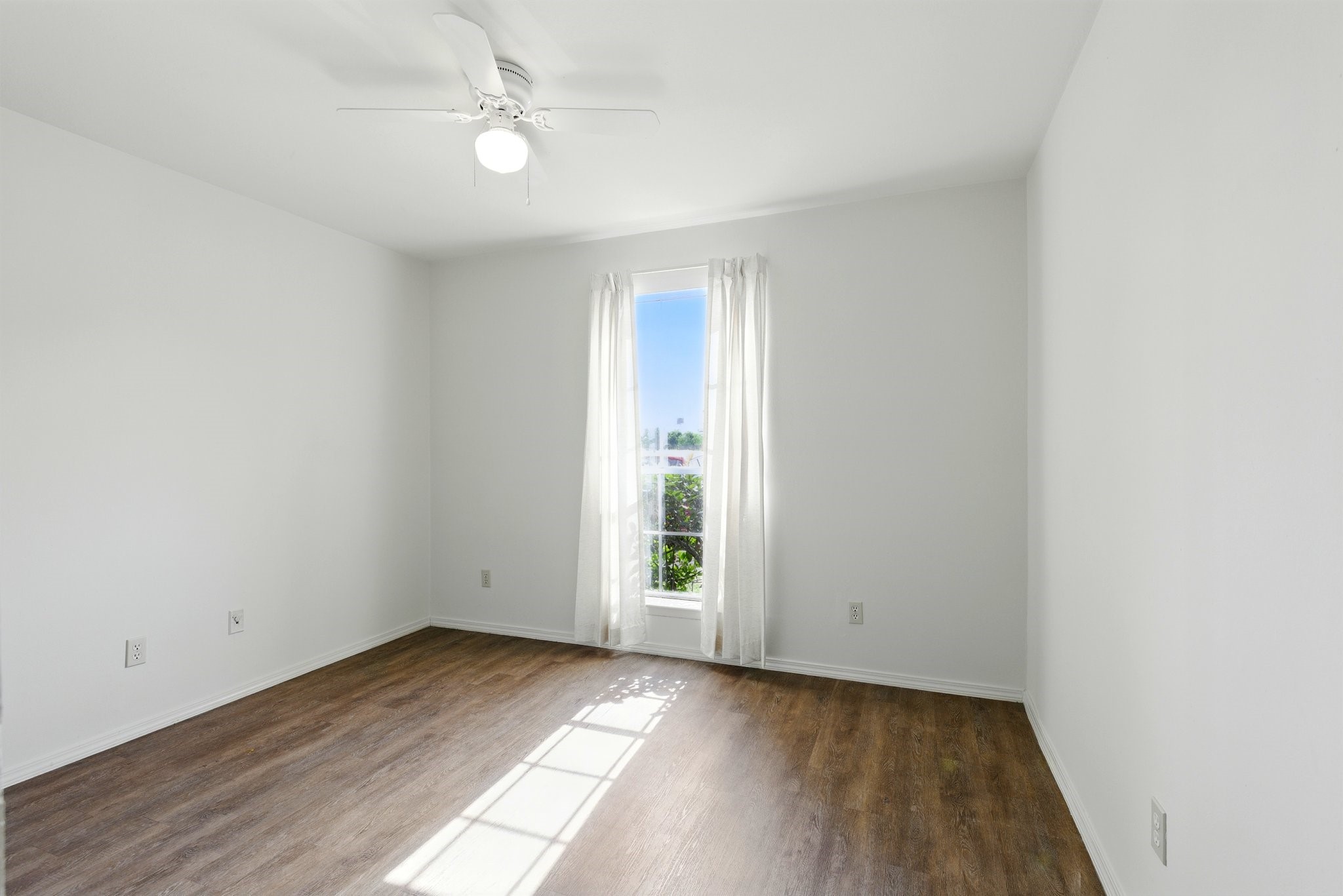 9410 Edgebrook Drive Houston, TX 77075 - Photo 4 of 11 an empty room with wooden floor ceiling fan and windows