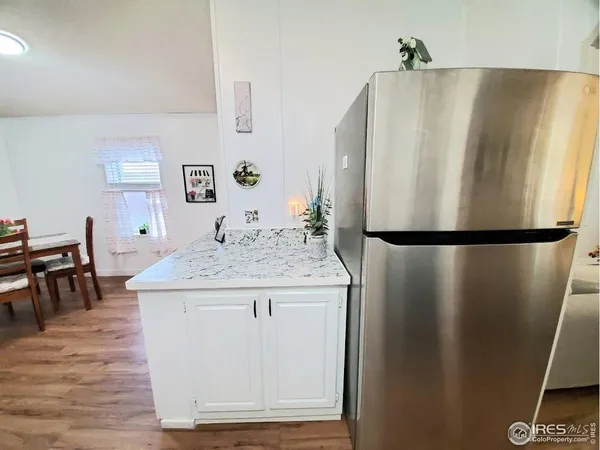 a kitchen with stainless steel appliances granite countertop a refrigerator a stove and a dining table