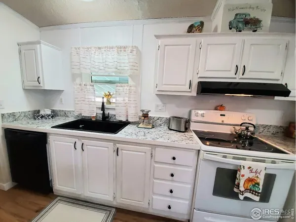 a kitchen with white cabinets and sink